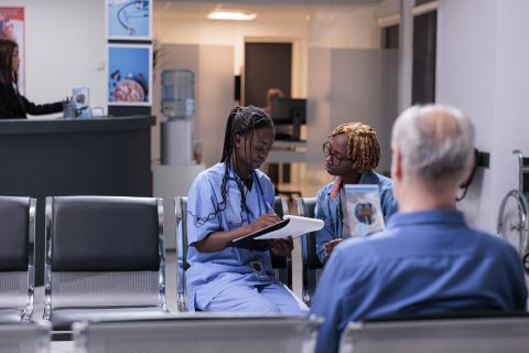 Female nurse taking notes at examination appointment with young patient, writing medical report papers to give healthcare insurance support in waiting room. Fillling in checkup form at cosultation.